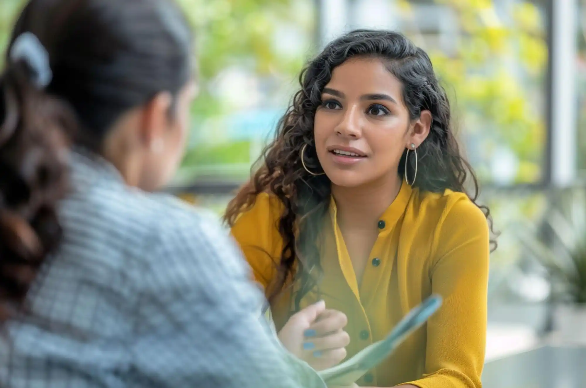 A Colombian student meets with a university financial aid advisor who is pointing at a document
