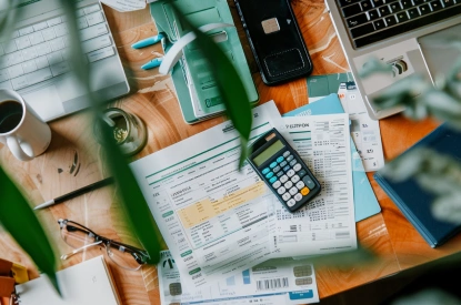 A flat lay photo shows a desk with a secured credit card, a printed loan approval letter. A small calculator is kept on the papers.