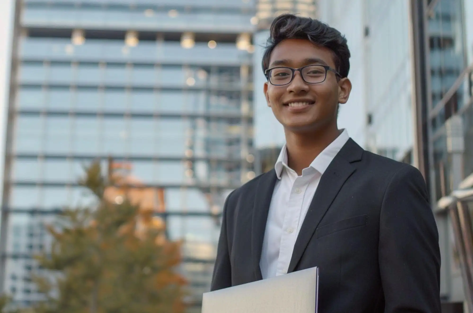 A graduate in business attire exits a mid-size U.S. tech company after a final-round interview.