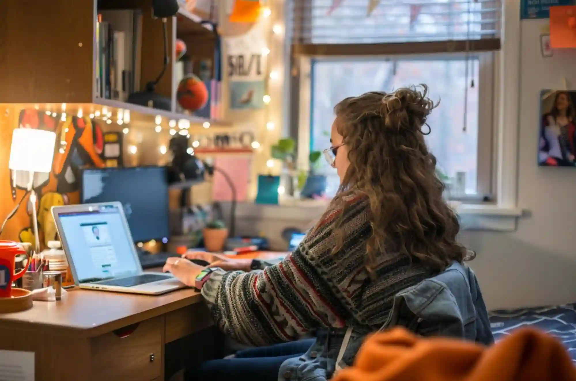 A student in a dorm room activates a new phone on their laptop