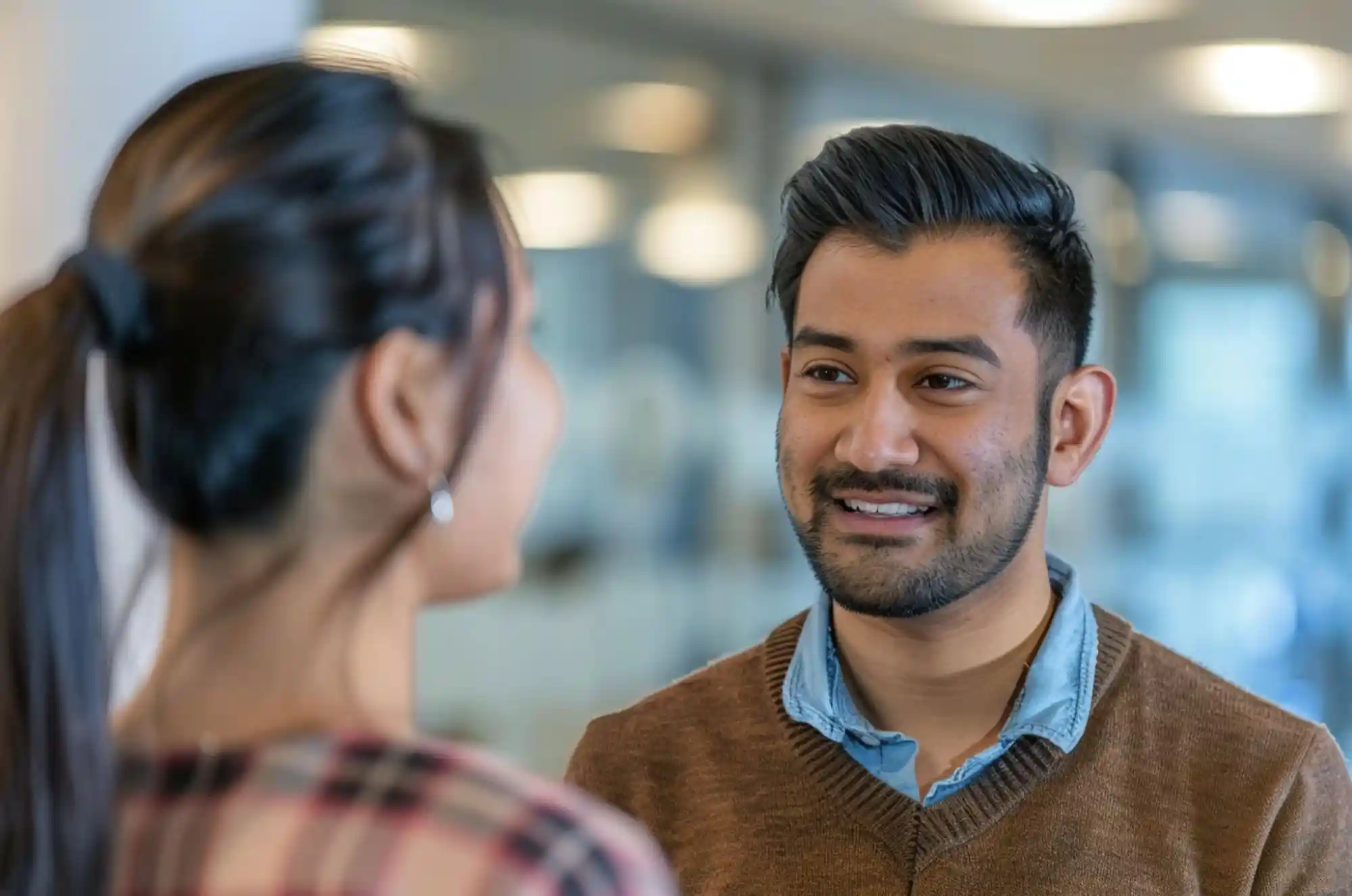 Indian international student meeting with a university international student advisor in a well-lit office.