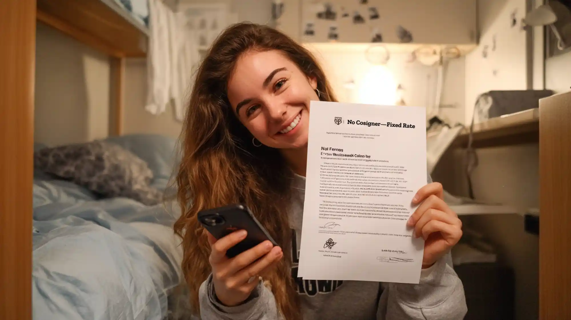 Insert Image alt text here  International student in dorm room smiling while texting family abroad, holding a loan letter titled “No Cosigner – Fixed Rate.”