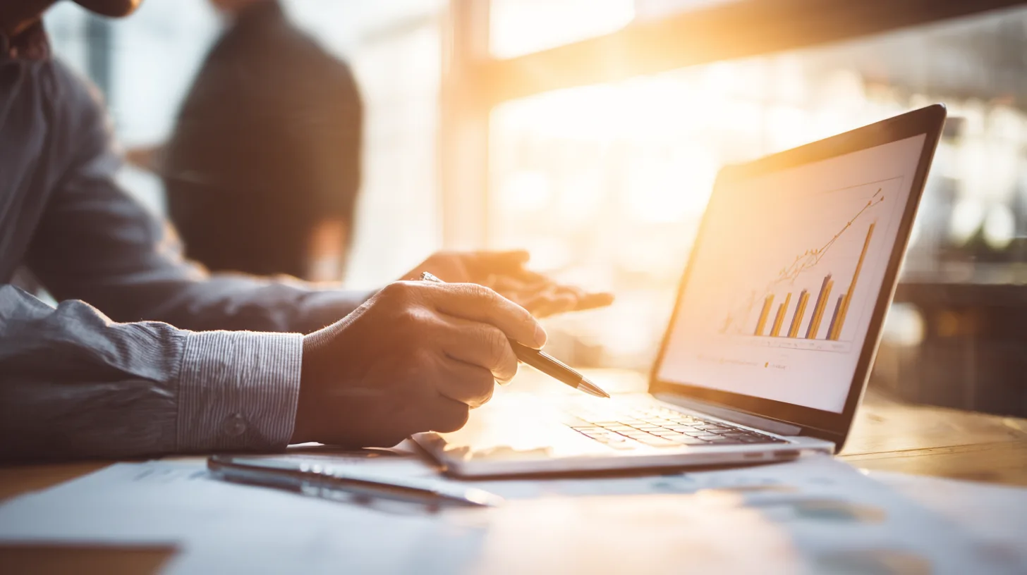 Insert Image alt text hereA financial advisor and a student sitting in a sunlit office, calmly reviewing a chart on a laptop.